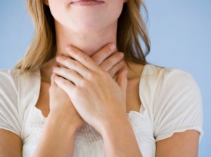 woman with hands on throat.