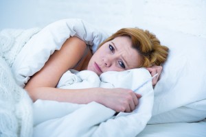 woman in bed sick unable to sleep suffering depression