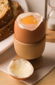 A4GBR4 Soft boiled egg with the top off in a breakfast setting.